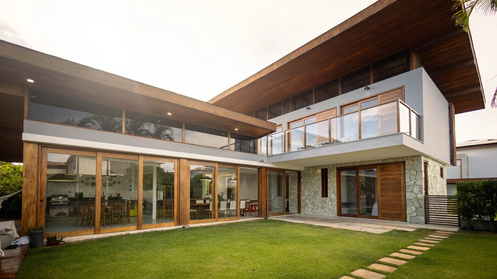 Illustrative stock photo of a contemporary home exterior with large glass windows and wood finishes